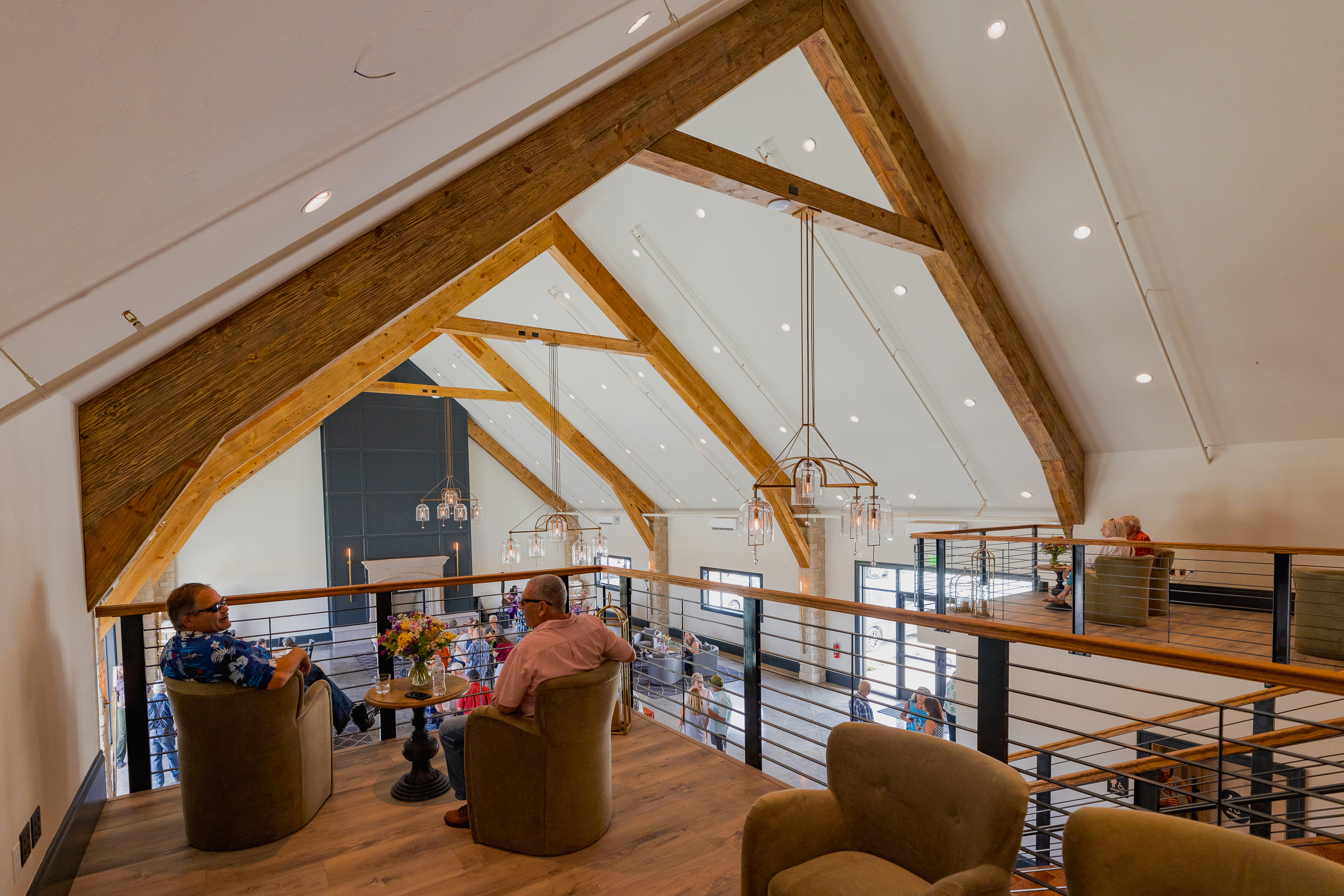 The mezzanine room at domenico winery amador with two people overlooking the balcony at the main grand room