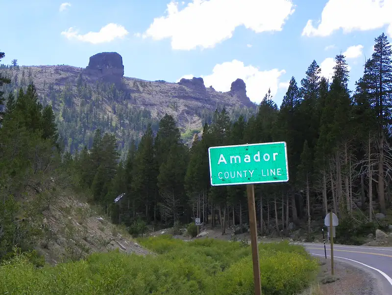 Amador County Line road sign with a mountainous background