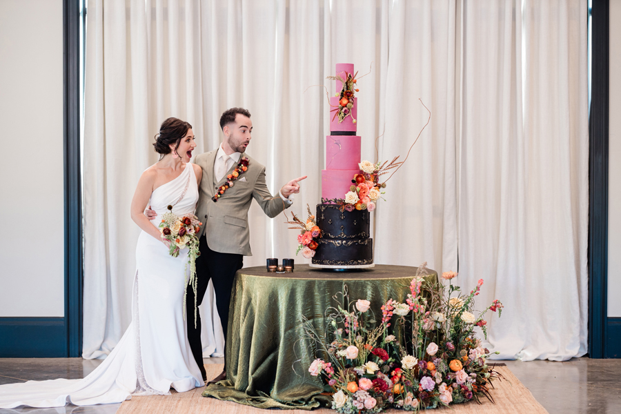 A wedding couple celebrating with their large 5 tiered wedding cake hosted at DOmenico Amador's weddings venue